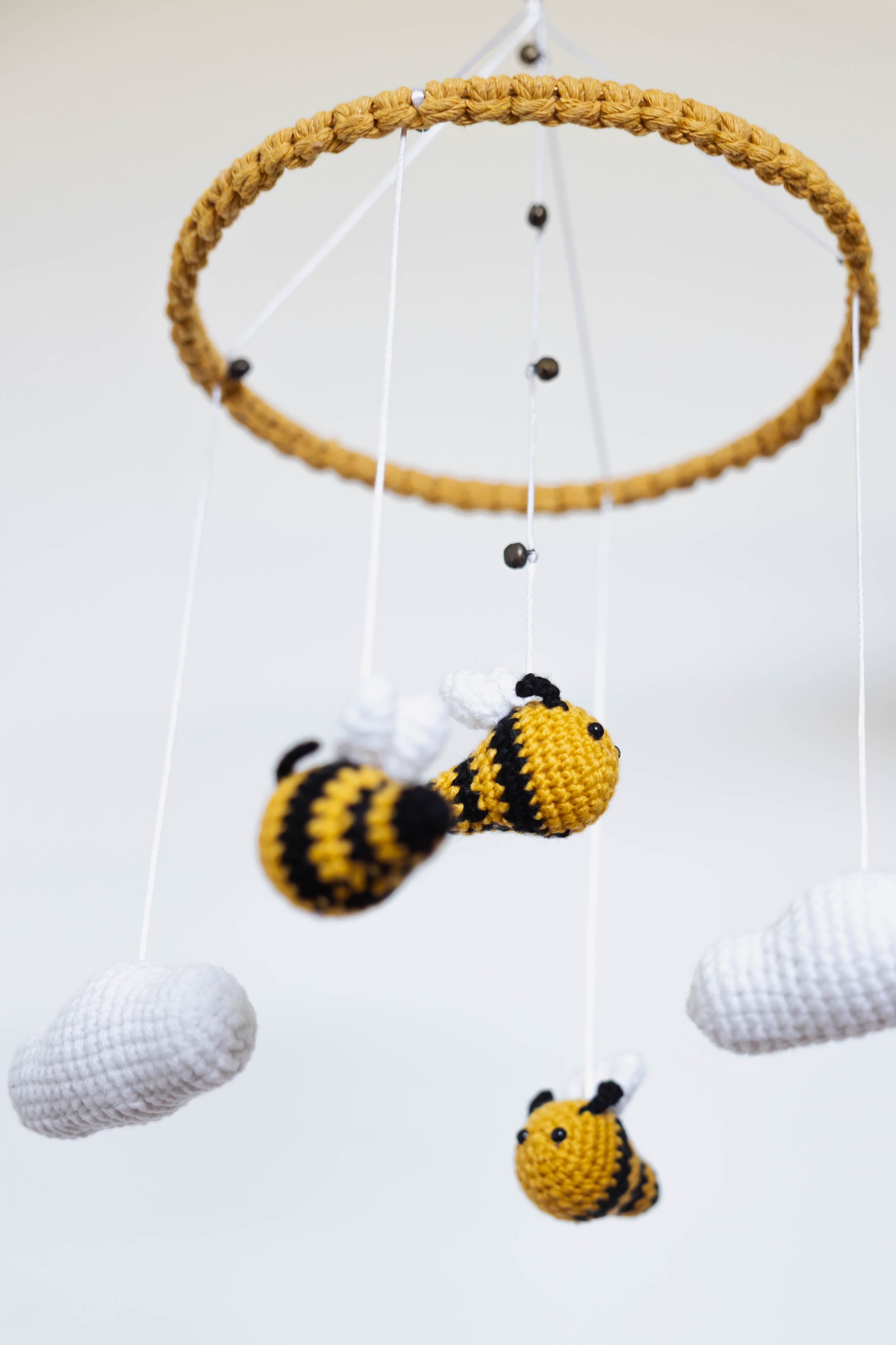Crocheted bee mobile with a yellow ring on a white background
