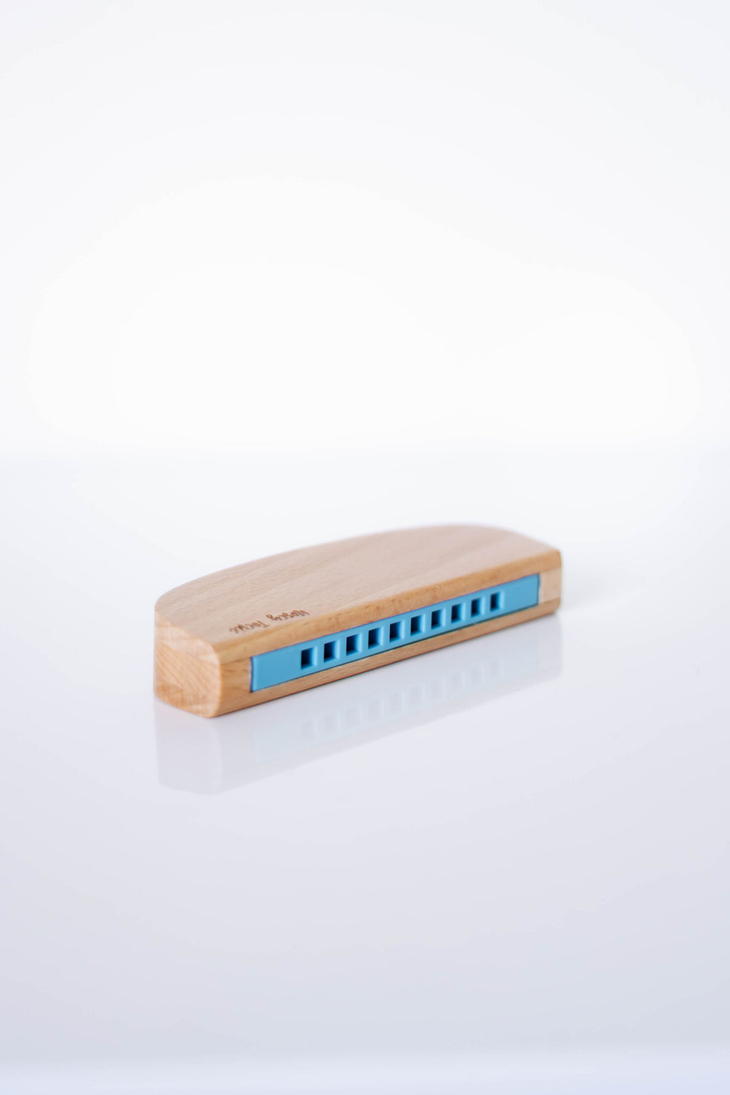 Wooden harmonica with blue reeds on a white background