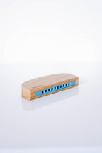 Wooden harmonica with blue reeds on a white background
