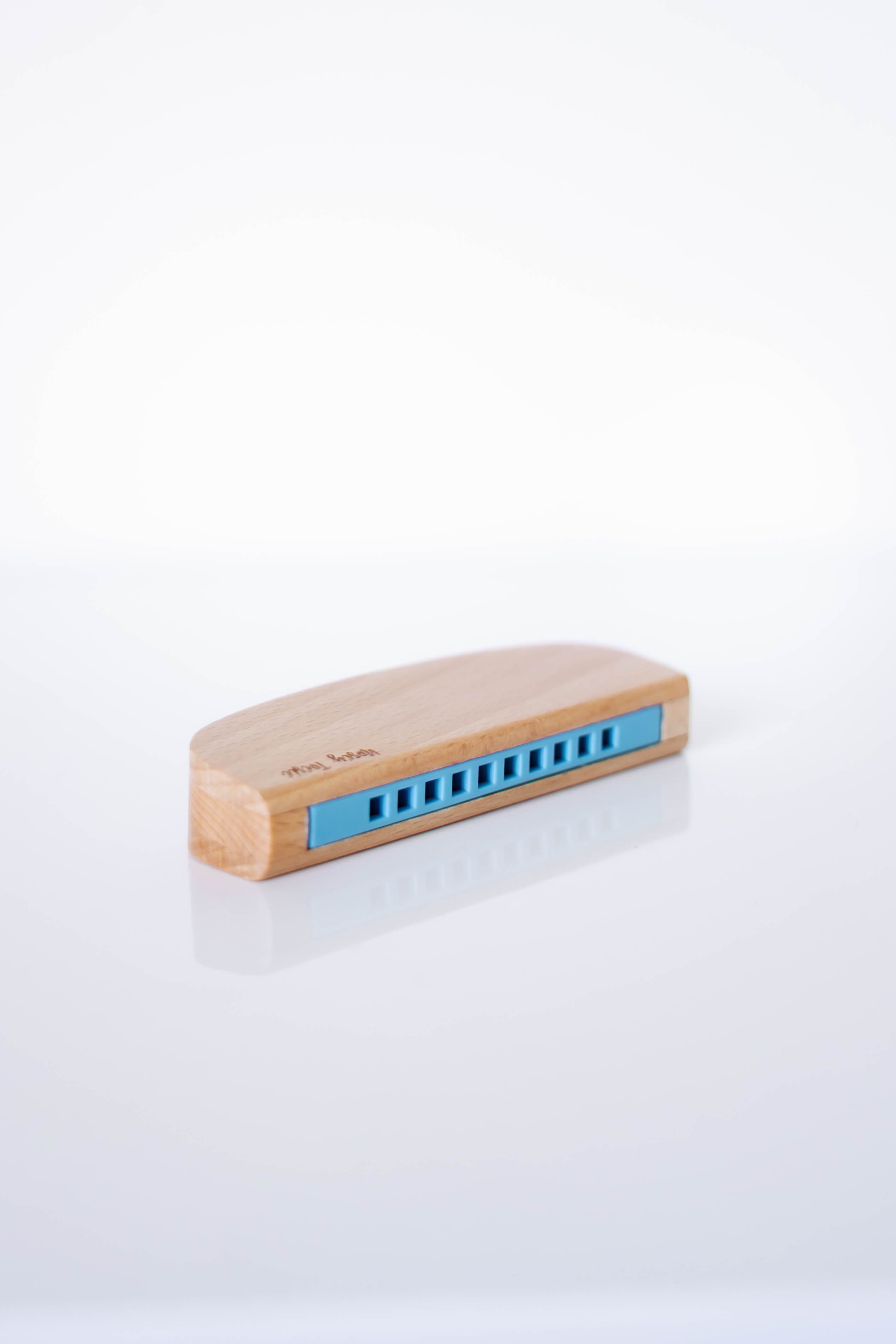 Wooden harmonica with blue reeds on a white background