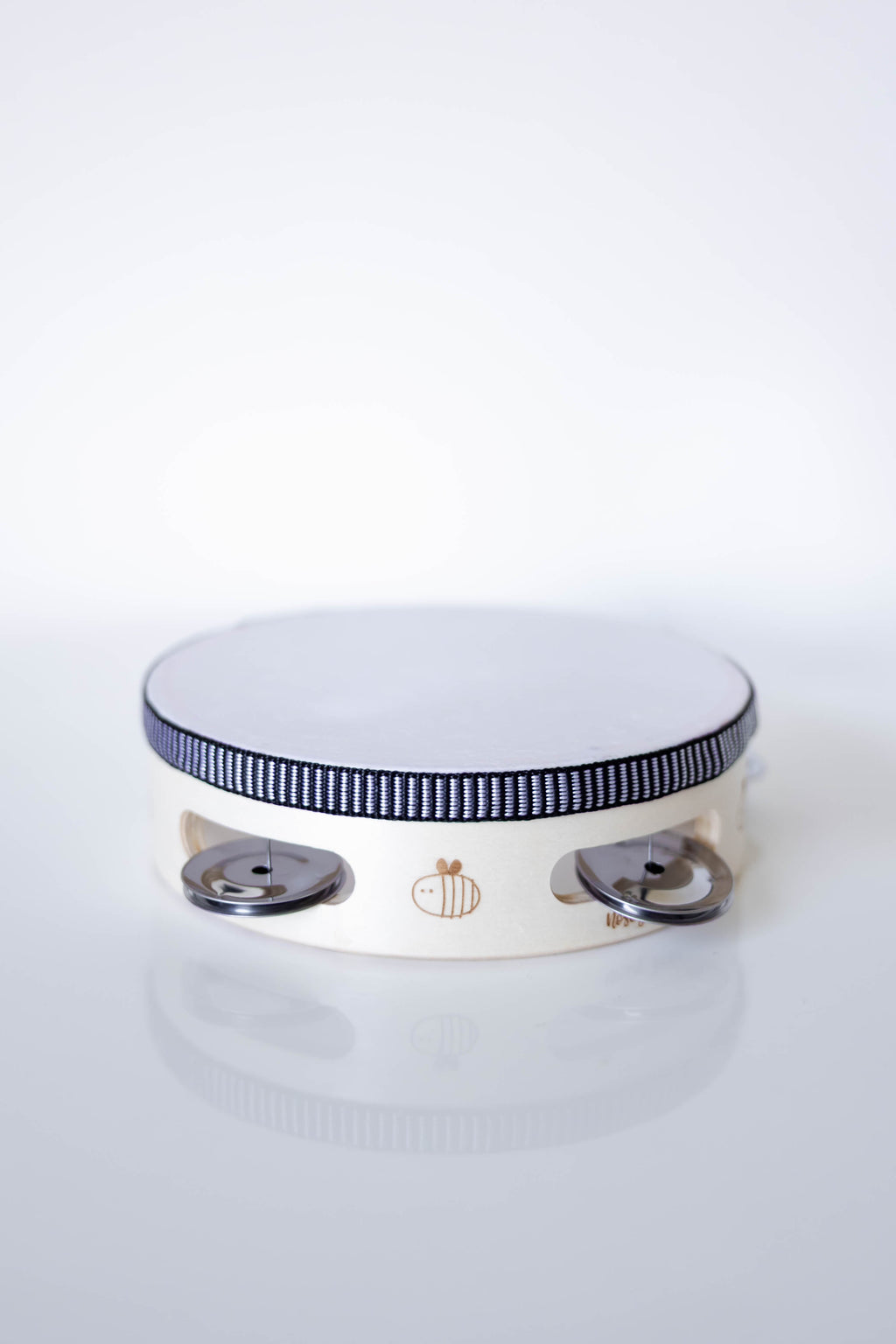 White and wooden tambourine with black rim on a white background