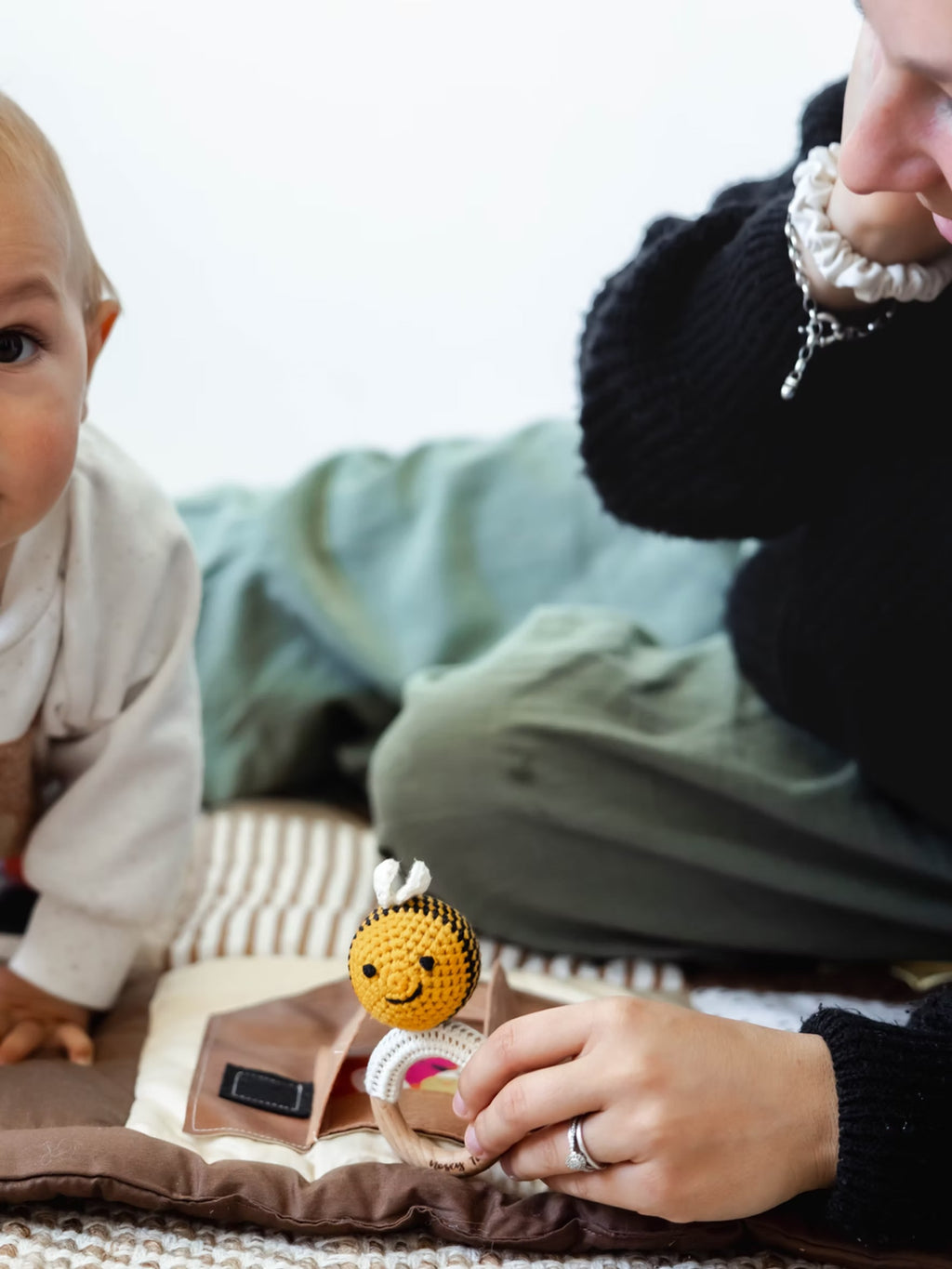 Baby and Mum on Sensory play Mat with a crocheted Bee baby rattle 