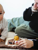Baby and Mum on Sensory play Mat with a crocheted Bee baby rattle 